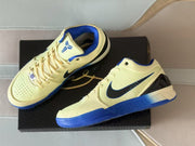 Top-angle view of the sneakers displayed on a black box, with the Kobe logo visible on the tongue.
