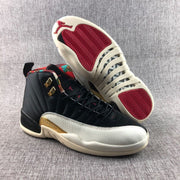 Pair of high-top sneakers showing the black upper, light textured forefoot, gold accents, and red outsole sections.