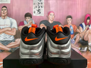 Rear view showing black heel panels, orange Swoosh logos and orange pull tabs.