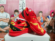 Angled view of the red sneakers showing the black Swoosh, gold graphics, black heel detail, and textured outsole.