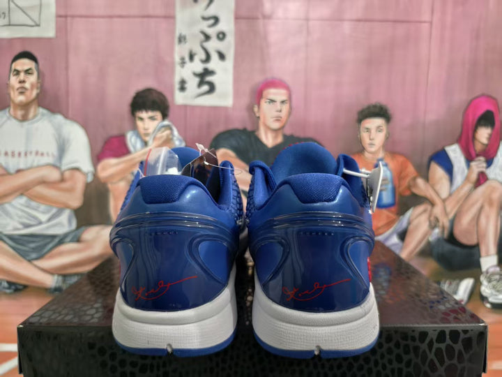 Rear view of blue Nike Kobe basketball shoes with white midsoles and red heel detailing.