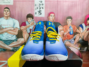 Front view showing the blue uppers, yellow laces, Under Armour logos, and SC tongue markings.