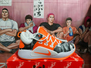 Side view showing the orange Swoosh, white midsole, patterned upper, and visible Nike Zoom text