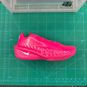 Side profile of a bright pink Nike basketball sneaker on a green measurement mat.