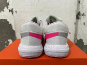 Rear view of white Nike basketball shoes with pink heel accents and a speckled midsole