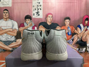 Rear view of light gray-white Nike basketball shoes with “12AM” heel tabs and dark speckled outsoles.