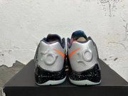 Rear view of silver Nike KD basketball shoes with orange accents and a black speckled midsole.