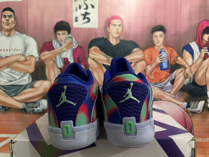 Rear view of dark blue Jordan basketball sneakers with multicolor panels, green heel accents, and light gray midsoles.