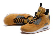 Angled view of tan Nike Air Max 90 high-top shoes showing the side Swoosh and visible Air unit