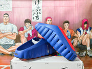 Blue Nike slides shown from the side, with ridged soles and red footbeds.