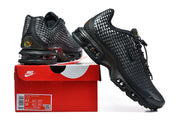 Black Nike Air Max Plus sneakers displayed with a red Nike shoe box and visible size label.