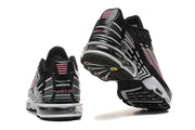 Rear and outsole views of black, white, and pink Nike Air Max Plus sneakers.