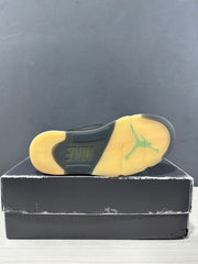 Bottom view of a Jordan Air Jordan 5 sneaker showing a translucent yellow-tinted outsole with Jordan and Nike markings.