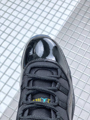 Close-up of the black sneaker toe box, black laces and tongue with blue and yellow branding details.