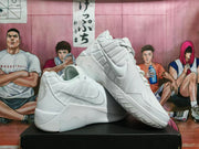 Pair of white Nike sneakers shown from the side and outsole, with layered panels, side Swooshes, and textured tread.