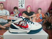 Side view of a white Nike basketball-style sneaker with a red Swoosh, multicolor printed side panel, and dark blue outsole.