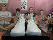 Front view of white high-top basketball shoes with lace-up closures.