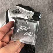 Close-up of the metallic hangtag and the winged ankle logo on the silver collar panel.
