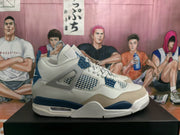 Side view of white, blue, and grey Air Jordan 4 sneakers