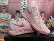 Pair of pink Nike basketball shoes shown from the side, highlighting the Swoosh and embroidered heel.