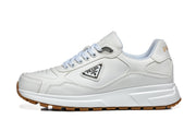 Side profile of a white Prada lace-up sneaker with a gum-colored outsole.