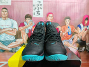 Front view of black lace-up basketball sneakers with Under Armour logos, pink trim and blue soles.