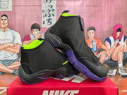 Angled view of a pair of black Nike high-top sneakers with purple outsole accents and neon yellow detailing.