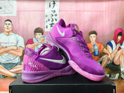 Purple Nike basketball sneakers shown from an angled side view, with white Swoosh details and patterned heel panels.