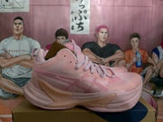 Side view of a pink ASICS basketball sneaker showing the mesh-like upper, tonal overlays and thick midsole.