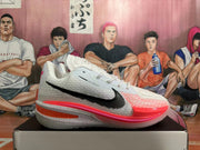 Side view of white Nike basketball shoe with black logo and pink-orange accents