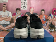 Rear view of black Brooks shoes showing textured heel panels and white midsoles.