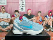 Side profile showing the textured upper, blue side accent, white midsole and gray heel structure.