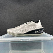 Side profile of a metallic silver sneaker with sculpted side detailing, black midsole accent, and white Nike Swoosh.