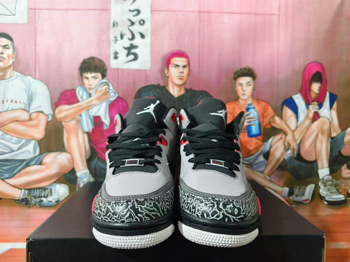 Front view of grey, black, and red Jordan sneakers with elephant-print toe overlays.