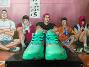 Front view of mint-green Nike basketball shoes with orange and blue accents