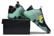 Mint green and black Kobe 11 sneakers shown on and beside a black shoe box.