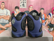 Rear view of black and purple Jordan basketball sneakers showing the padded collars, purple heel panels, and black outsole.