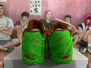 Rear view of green basketball sneakers showing brown heel branding, padded collars, and textured green uppers.
