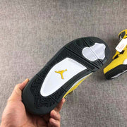 Outsole close-up showing black herringbone-style tread, white traction sections, and a yellow Jumpman emblem.