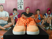Front view of the pair showing orange laces, perforated toe boxes, orange uppers, and white textured outsoles.