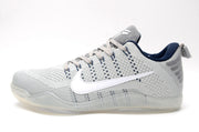 Side view of a gray Nike Kobe 11 shoe with white Swoosh and translucent-looking sole