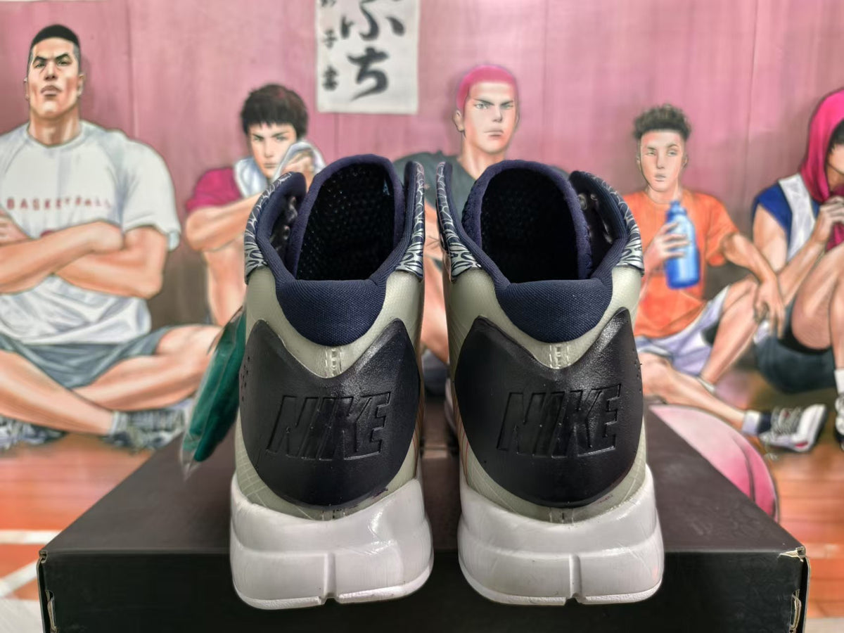 Rear view of a pair of black, grey and white high-top Nike basketball sneakers on a shoebox.