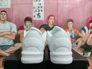 Rear view of the pair of white Nike basketball sneakers, showing the heel and outsole design.
