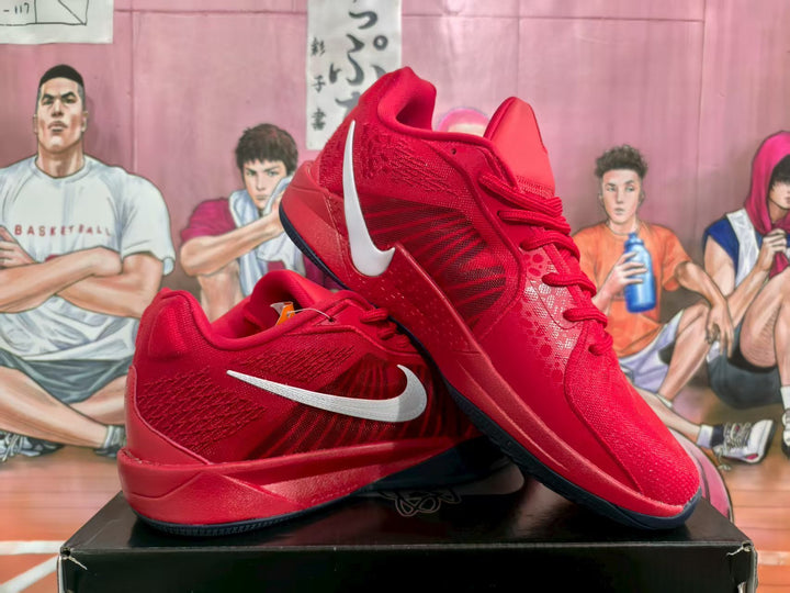 Pair of red Nike basketball sneakers with white Swoosh branding displayed on a black box.