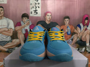 Front view showing the blue textured toe boxes, yellow laces, and peach-and-blue outsole design.