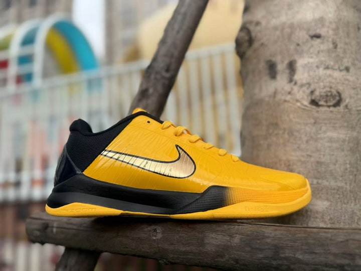 Side view of a yellow and black Nike Kobe 5 basketball shoe.