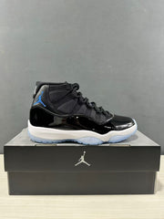 Side view of a black and blue high-top Jordan sneaker displayed on a black shoe box.