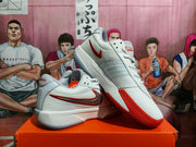 Angled view of the paired white and red basketball sneakers showing the outsole and side branding.