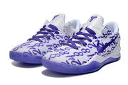 Pair of white and purple Kobe 8 sneakers with purple graphic lettering across the upper.