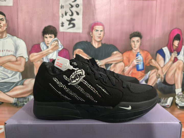 Pair of black Nike low-top sneakers displayed on a box, with rhinestone-style side detailing, a white Swoosh, and a round decorative hangtag.